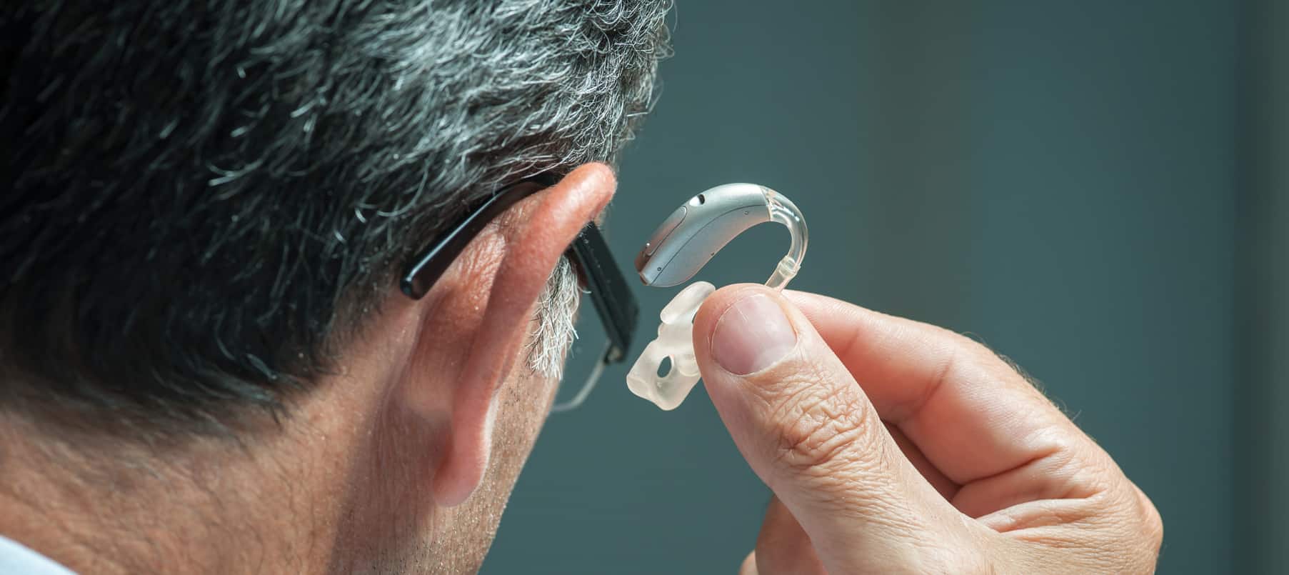 Un homme entrain d'admirer une prothèse auditive